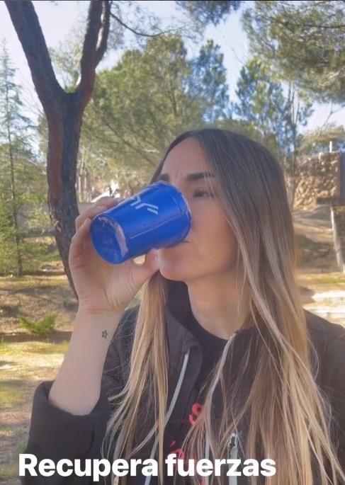 Una chica tomando Immunocal, se ve el vaso azul con el logo de Immunotec