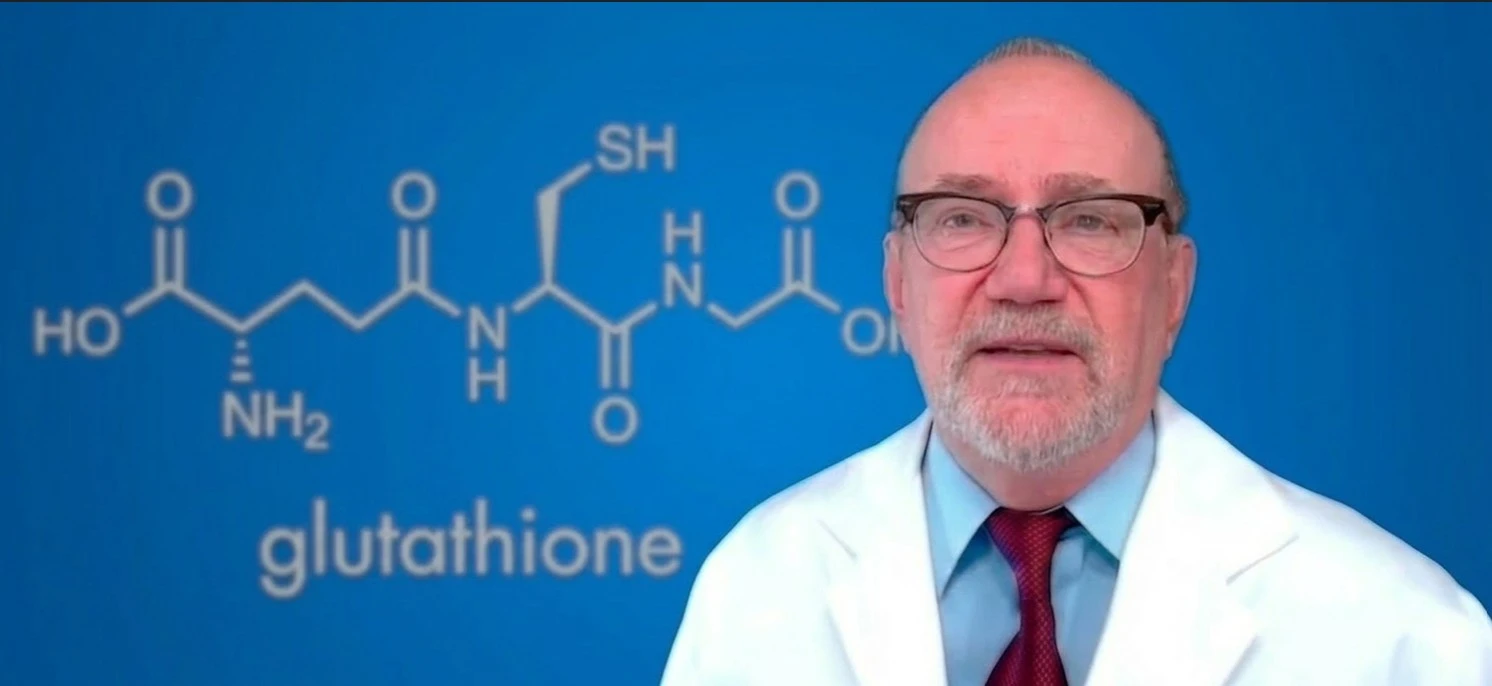 Imagen del Dr Jimmy Gutman hablando y en el fondo el simbolo quimico del glutatión